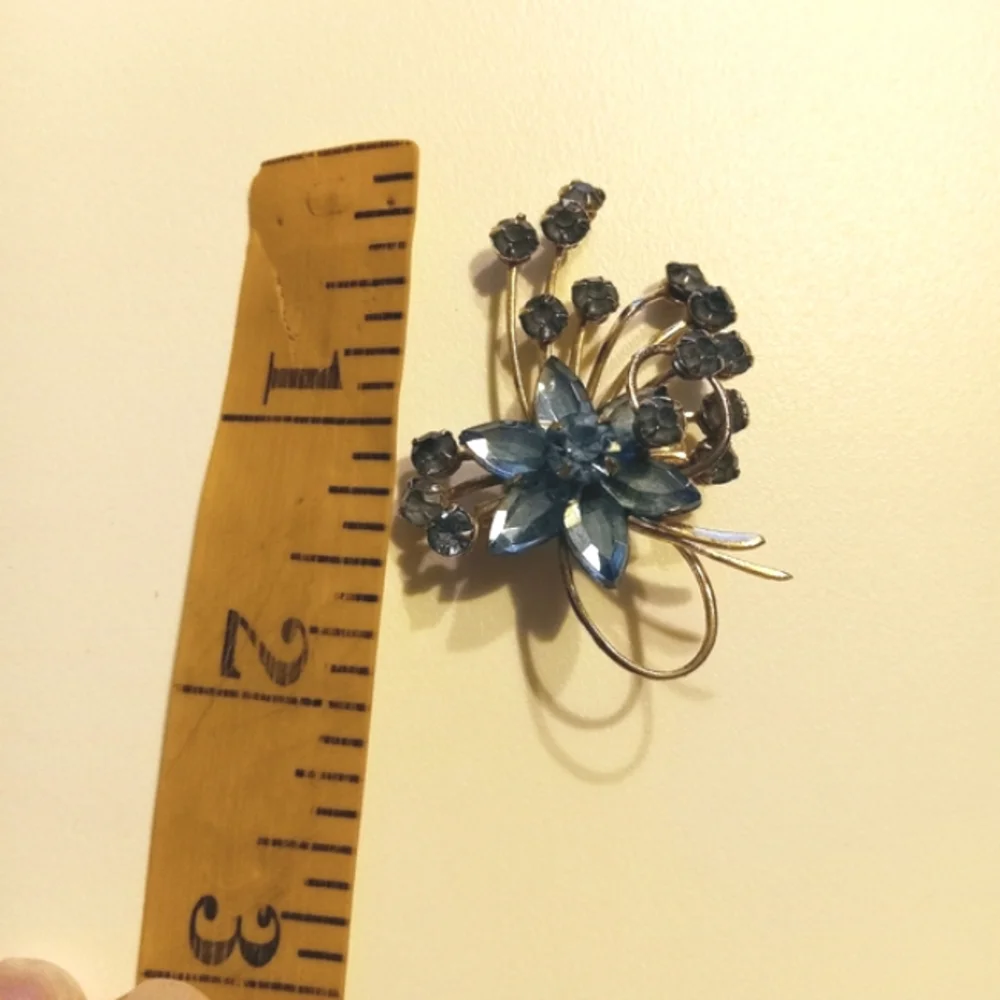 Vintage goldtone blue rhinestone flower brooch.